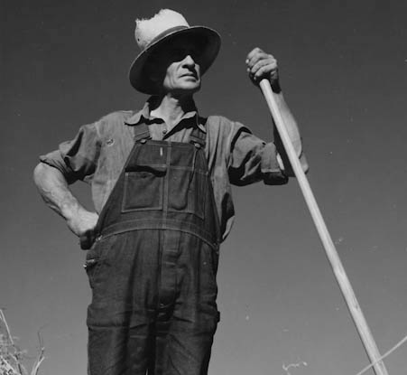 Farmer wearing overalls and a hat.